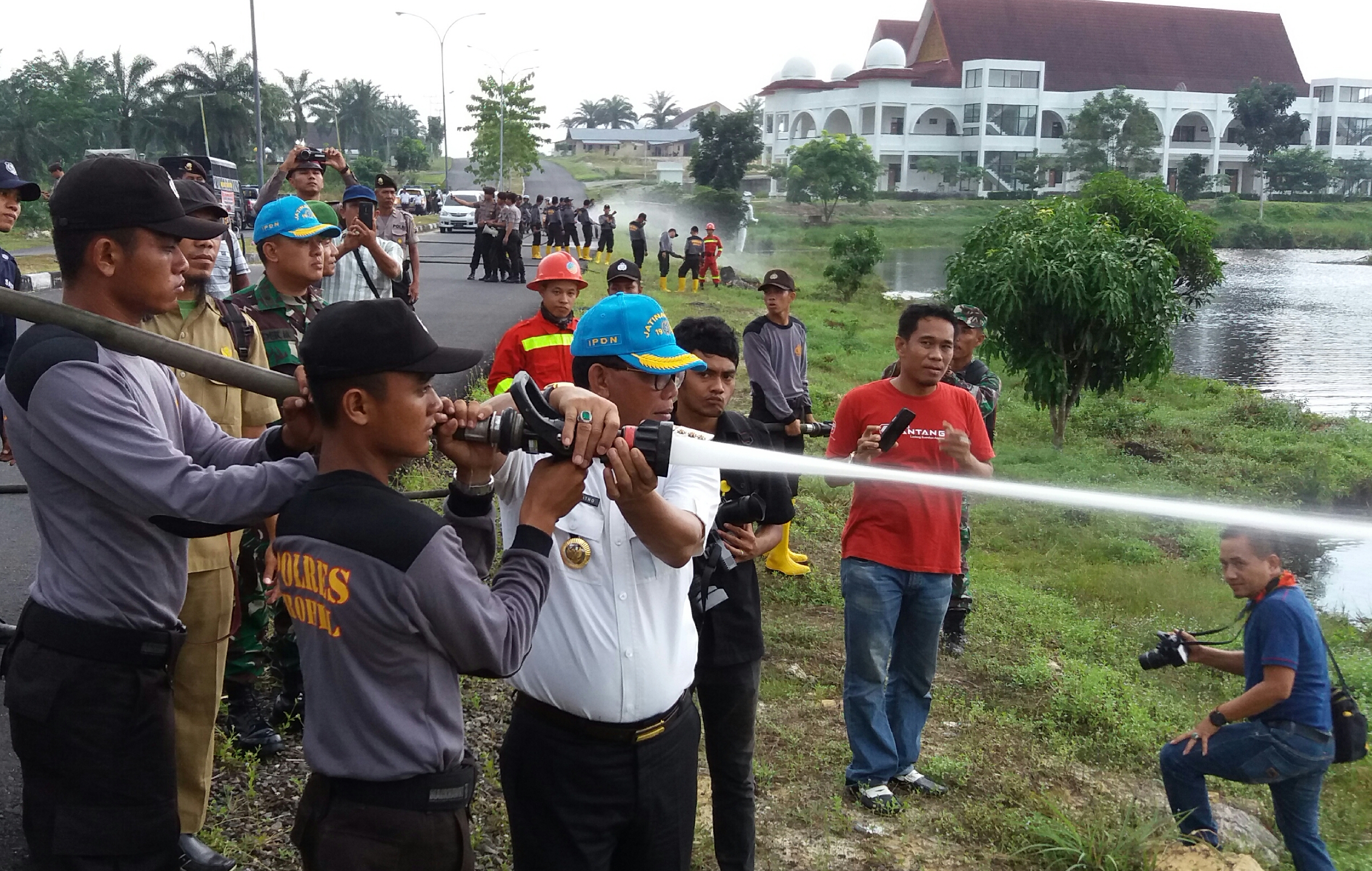 Bupati Suyatno didampingi tim opsnal siaga Karlahaut Polres Rohil saat mencoba unit pompa air didanau buatan kampus IPDN Rohil, Riau.